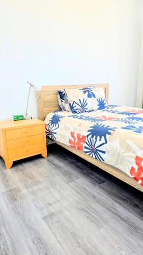 a bedroom with a bed and a night stand at Cozy Room near airport and train station in Perth