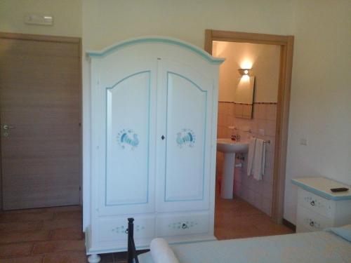 armadio bianco in bagno con lavandino di Santu Paulu Country House a Posada