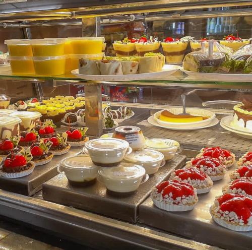 eine Vitrine mit vielen verschiedenen Desserts in der Unterkunft Studio no Centro da Cidade in Parauapebas