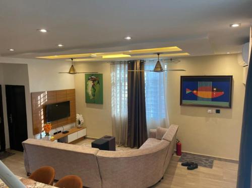 ein Wohnzimmer mit Sofa und Fernseher in der Unterkunft Two Sisters Villa in Accra