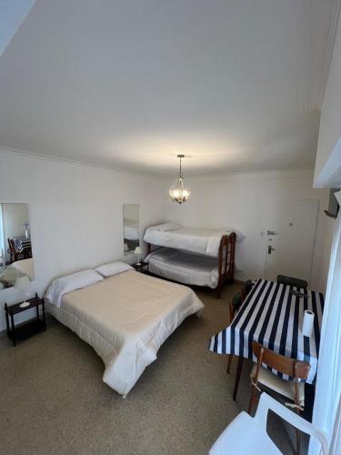 a bedroom with two beds and a table and chairs at Depto 1 ambiente frente al mar y céntrico in Mar del Plata