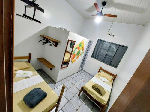 a room with two beds and a table and chairs at Hotel Pasettus in Bela Vista do Paraíso
