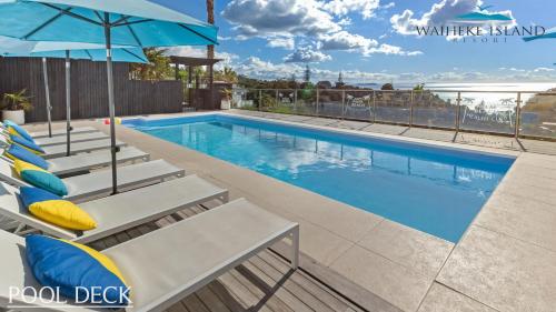 Waiheke IslandSerene One Bedroom Seaview Chalet的带躺椅和遮阳伞的游泳池