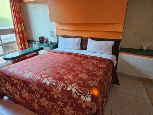 a bedroom with a large bed with a red blanket at Motel Éxtasis in Mexico City