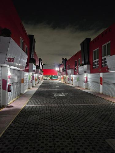 een lege parkeerplaats 's nachts met rode gebouwen bij Motel Éxtasis in Mexico-Stad
