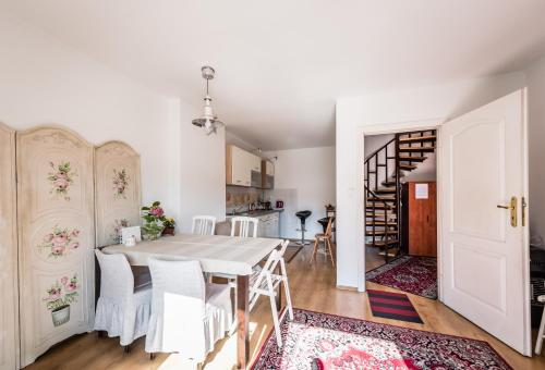 Dom pod Różą في Rząska: مطبخ وغرفة طعام مع طاولة وكراسي بيضاء