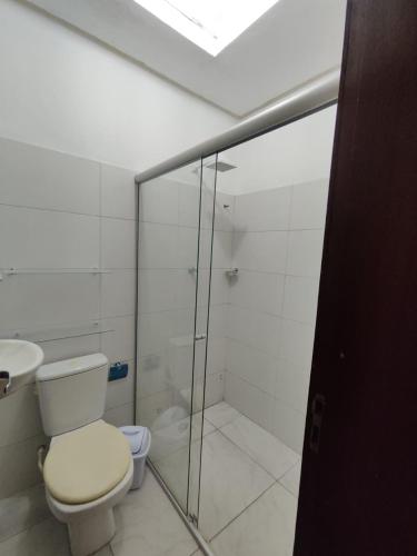 a bathroom with a toilet and a glass shower at Suíte Nazaré in Belém