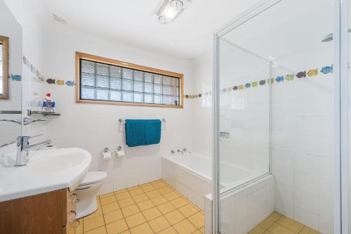ein Badezimmer mit Dusche, Toilette und Waschbecken in der Unterkunft The Beachfront in Lake Cathie