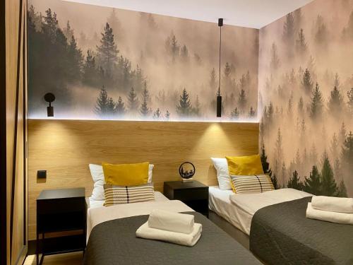 Un dormitorio con dos camas con almohadas amarillas. en REST4U APARTAMENTY z SAUNAMI, en Szczyrk