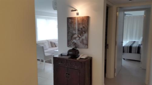 una sala de estar con un armario de madera y una pintura en la pared en Punta Del Este Excepcional Ubicación, en Punta del Este