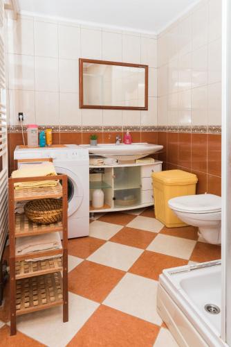 a bathroom with a washing machine and a sink at Apartmani Španja in Vodice