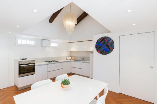 a white kitchen with a white table and chairs at San Marco Comfort in Venice