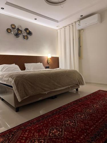a bedroom with a large bed and a red rug at شقة الفخامة in Medina