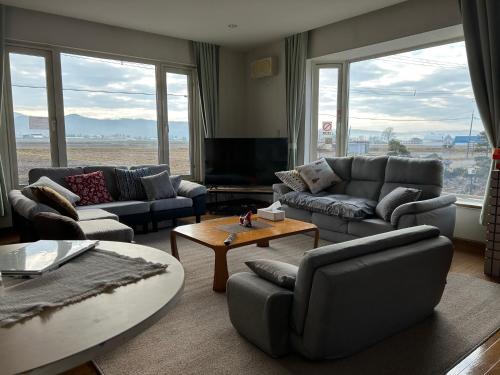 a living room with couches and a coffee table at countryside FURANO in Nakafurano