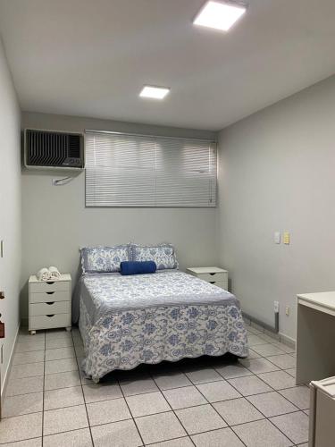 普雷图河畔圣若泽Suítes nas proximidades HB, HCM e Famerp的一间卧室，里面有一张床，铺着蓝色被子。