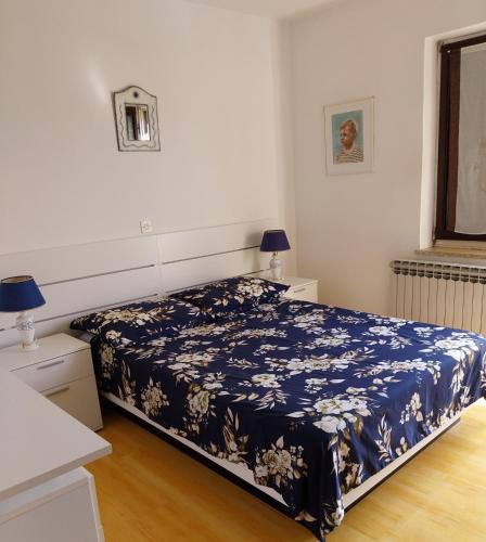 a bedroom with a bed with a blue blanket at Apartments with parking space Rabac, Labin - 7438 in Rabac
