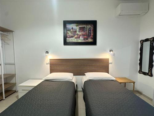 Lora's House 5Terre في لا سبيتسيا: سريرين يجلسان بجانب بعضهما البعض في غرفة