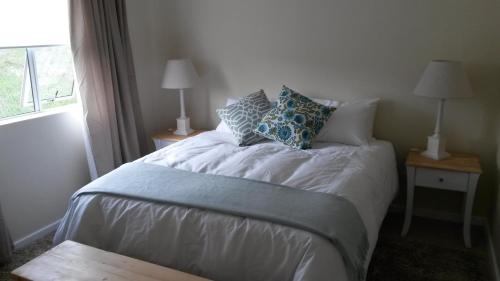 a bedroom with a bed with pillows and a window at 210 Atlantic Sun in Bloubergstrand