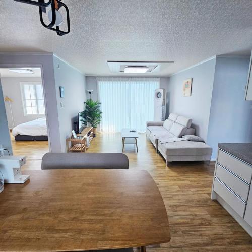 una sala de estar con un sofá y una mesa en Ocean House PH, en Pohang