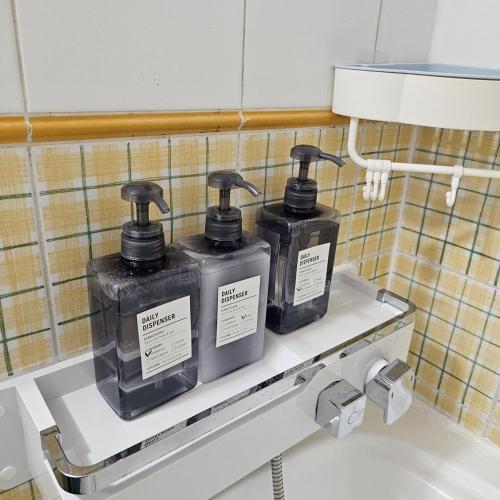 Dos botellas de jabón en un estante en un baño. en Ocean House PH, en Pohang