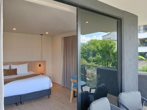 a hotel room with a bed and a balcony at Hotel Rulay Medellin in Medellín