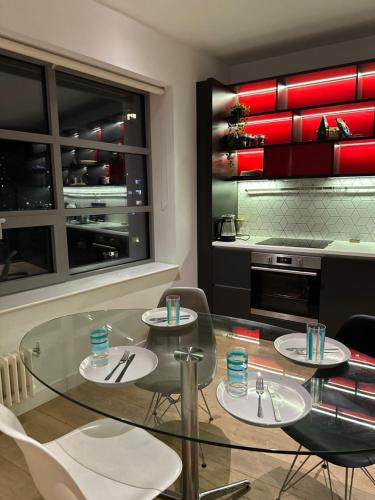 a dining room with a glass table and chairs at En-suite Room LUXURIOUS 2 bed Flatshare in London
