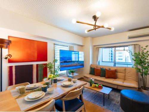 a living room with a table and a couch at MY STORY Familia 801-無料駐車場 in Takamatsu