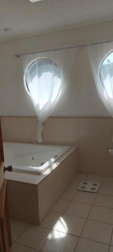 LaborcillasArboledas的一间带2扇窗户和浴缸的浴室