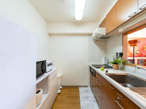 a kitchen with a sink and a microwave at MY STORY Familia 801-無料駐車場 in Takamatsu