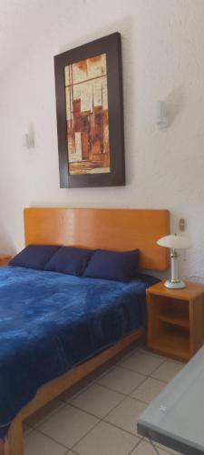 LaborcillasArboledas的卧室配有蓝色的床,墙上挂着一幅画