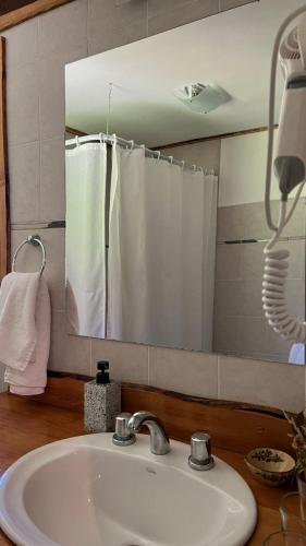 a bathroom with a sink and a mirror at Chacra Kaiken Lodge in Perito Moreno