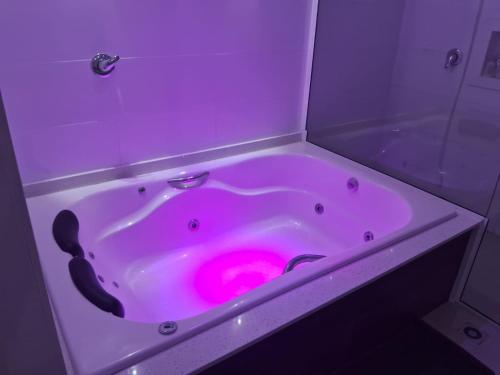 a pink bath tub with a pink circle in it at Casa com piscina, suite com hidro em Blumenau in Blumenau
