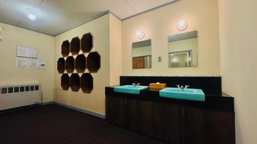 um banheiro com duas pias e um espelho em 志賀 石の湯ホテル em Yamanouchi