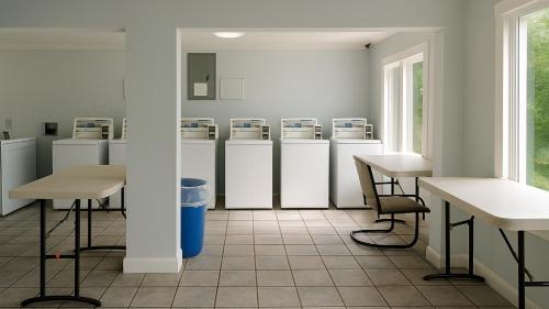 a room with several refrigerators and a table and chairs at Gated 2 Double Beds Studio with Full Kitchen 106 in Baton Rouge