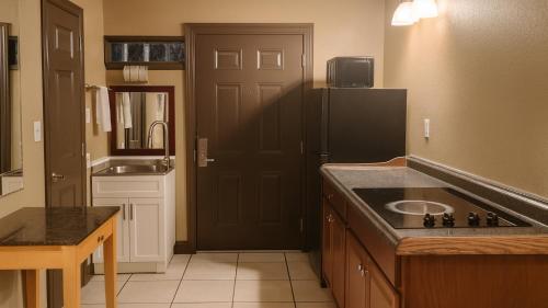 a kitchen with a sink and a black refrigerator at Gated 2 Double Beds Studio with Full Kitchen 106 in Baton Rouge