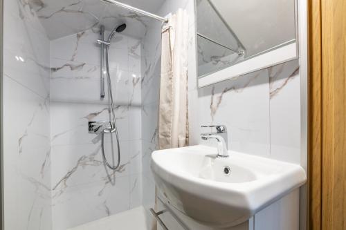 a white bathroom with a sink and a shower at Duplex Cosy - Moderne - 15min Versailles in Saint-Forget
