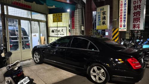 una macchina nera parcheggiata di fronte a un garage di 山頂洞人 a Fengyuan