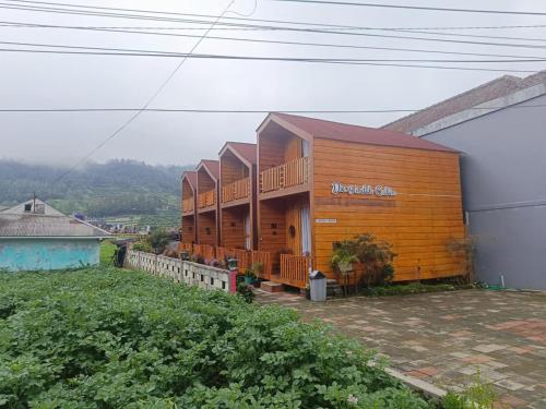 a large wooden building on top of a hill at Dieng Indah Villa & Cabin by Hello Room in Dieng