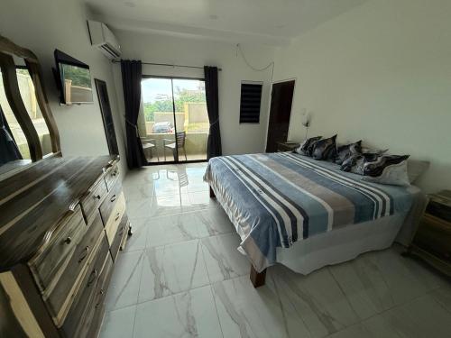 ein Schlafzimmer mit einem Bett, einer Kommode und einem Fenster in der Unterkunft G&M Hill view Horizon in Kingston