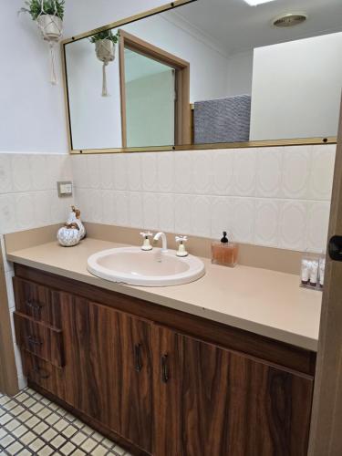 a bathroom with a sink and a mirror at Parklands Cottage in Cowes