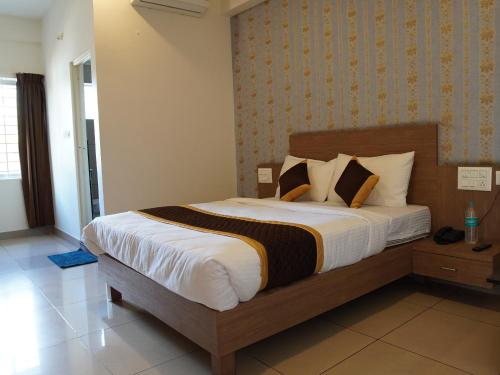 a bedroom with a large bed in a room at Hotel Janani Mansion in Mysore