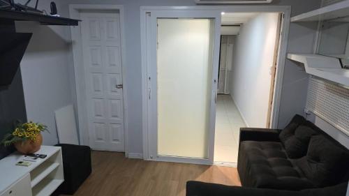 uma sala de estar com um sofá e uma porta em Tropical Suítes-Próx Praça da República em Belém