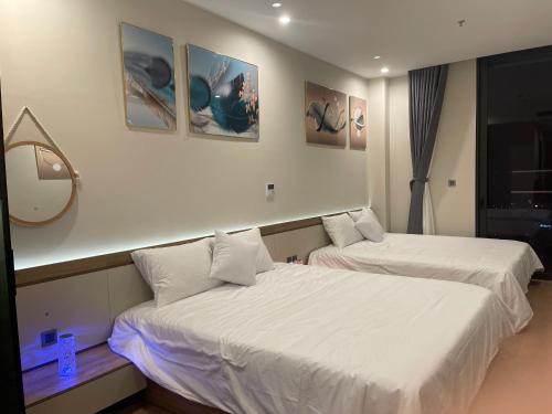 a bedroom with two beds and a mirror on the wall at HomeStay ICON40 HẠLONG in Ha Long