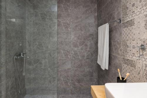 un bagno grigio con doccia e lavandino di Tsimiski View CityCenter Boutique Suite - By Nuvia Domus a Salonicco