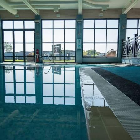 a large swimming pool in a building with water at Number 8 Sandpiper ,NEW 6 Berth Elegant Holiday Home Mill Rythe Hayling Island Free WiFi & Parking in Hayling Island