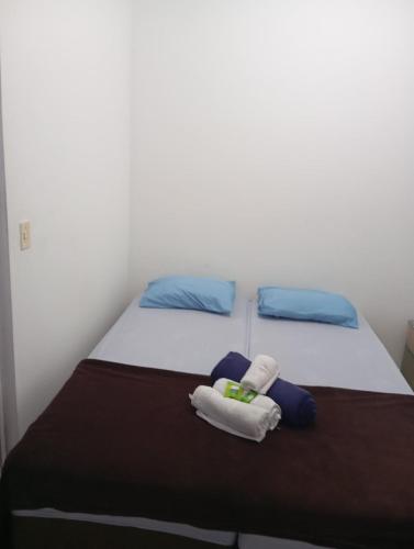 a bedroom with two beds with towels on it at KITNET - Completa e Individual - Pousada Itapetininga in Itapetininga