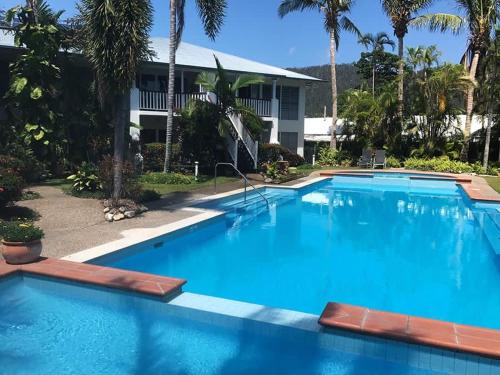 a large blue swimming pool in front of a building at Sunrise Cove in Airlie Beach