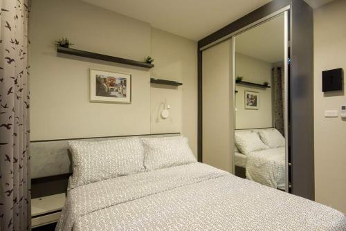 a bedroom with a bed and a mirror at The Base 88-67 F5 in Pattaya