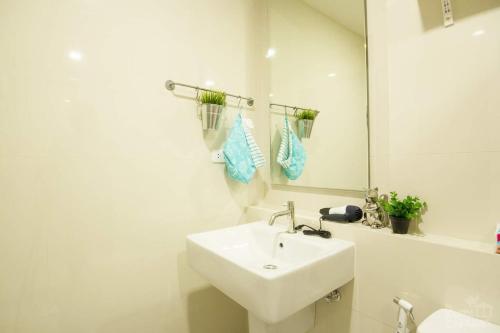 a white bathroom with a sink and a mirror at The Base 88-67 F5 in Pattaya