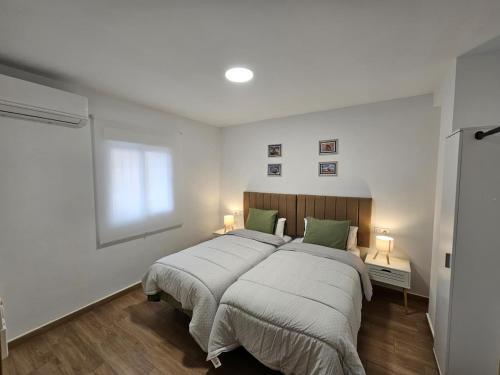 a bedroom with a large bed with green pillows at Casa Hernán Cortés in Málaga